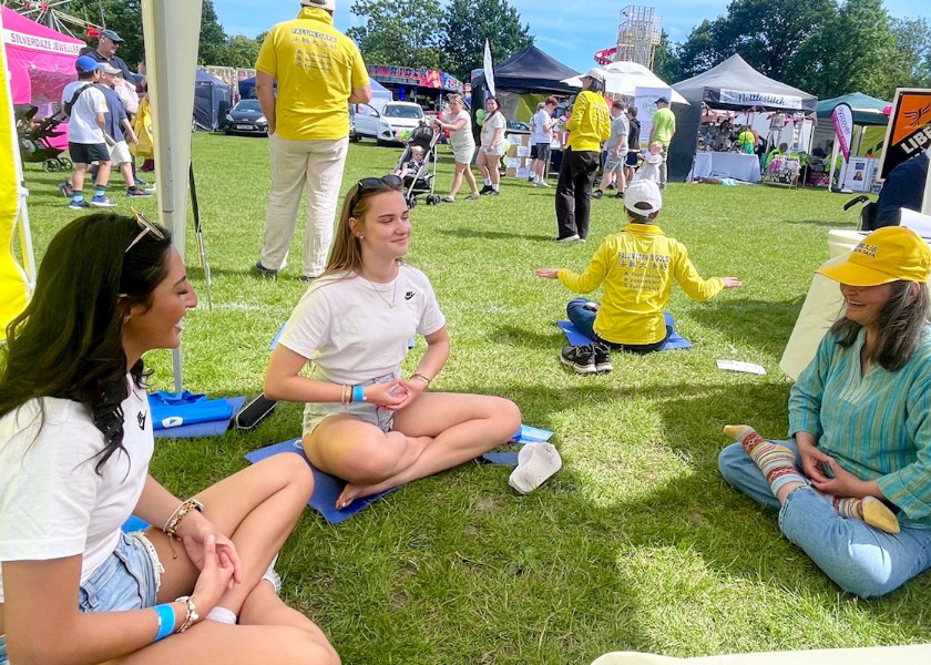 Image for article Orang-orang Mempelajari Perangkat Latihan Falun Dafa Selama Village Day di Surrey, Inggris